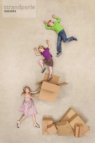 Kinder springen aus Pappkartons