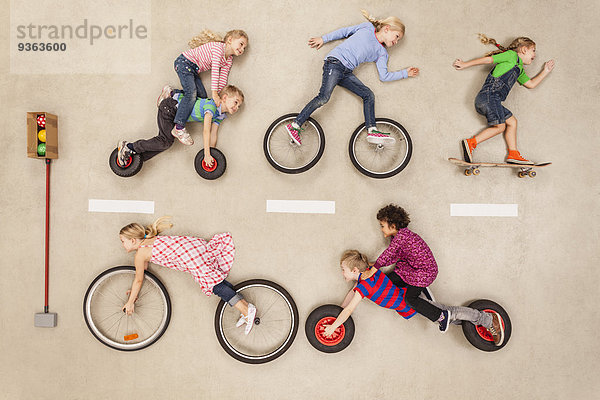 Kinder Radfahren und Skaten auf der Straße