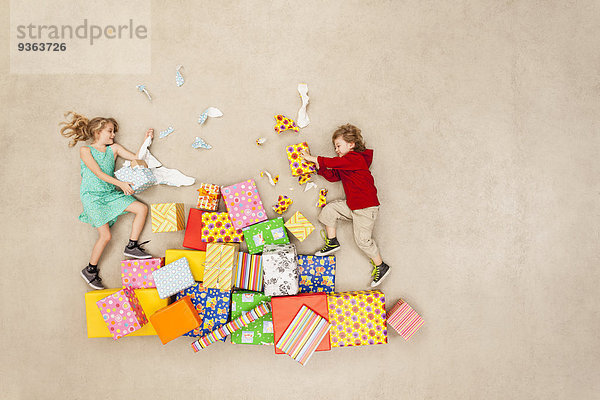 Junge und Mädchen beim Auspacken von Geschenken
