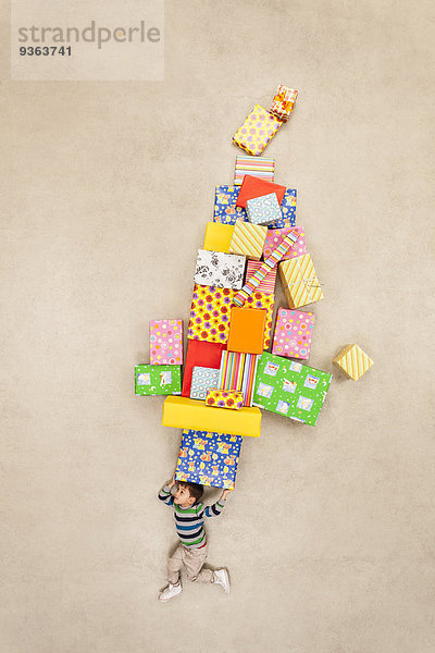 Boy Balancing Stapel von Geschenken