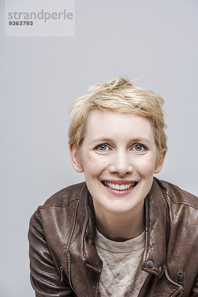 Porträt einer lächelnden Frau mit blonden kurzen Haaren