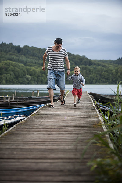 Deutschland  Rheinland-Pfalz  Laacher See  Vater läuft mit Sohn auf Steg