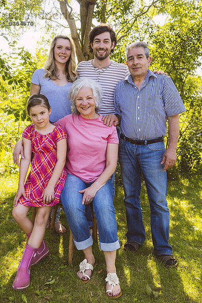 Porträt einer Drei-Generationen-Familie im Garten
