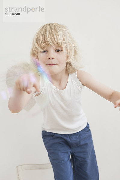 Porträt eines lächelnden kleinen Jungen beim Betrachten einer Seifenblase