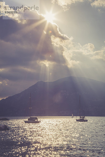 Italien  Veneto  Brenzone  Segelboote auf dem Gardasee gegen die Sonne