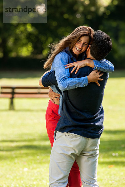Ein Paar umarmt sich im Park.