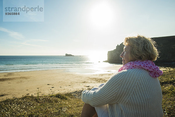 Frankreich  Bretagne  Camaret-sur-Mer  Seniorin an der Küste sitzend