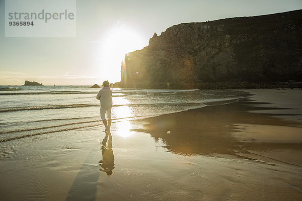 Frankreich  Bretagne  Camaret-sur-Mer  Seniorin am Strand stehend