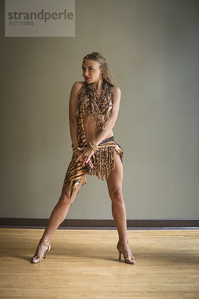 Tänzerin im Tanzstudio. Eine Frau mit ausgestrecktem Bein und spitzer Zehe.