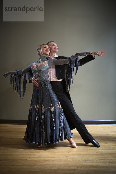 Ein Mann und eine Frau tanzen zusammen in einem Tanzstudio.