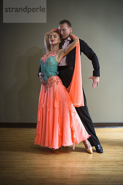 Ein Mann und eine Frau tanzen zusammen in einem Tanzstudio.