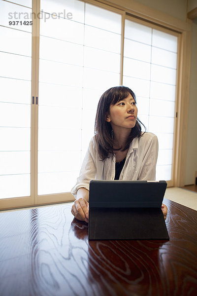 Eine Frau sitzt an einem Tisch mit einem Laptop-Computer.