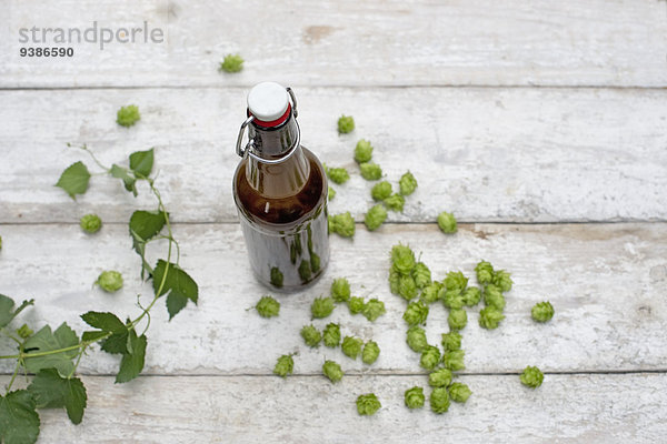 Bierflasche und Hopfen auf einem Holztisch