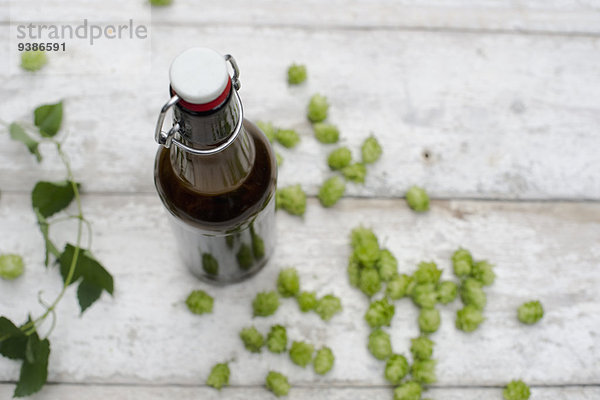 Bierflasche und Hopfen auf einem Holztisch