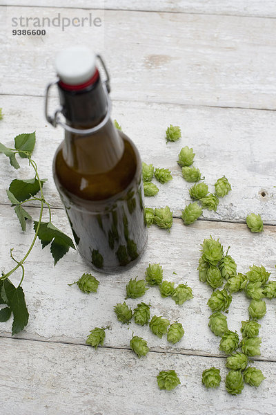 Bierflasche und Hopfen auf einem Holztisch