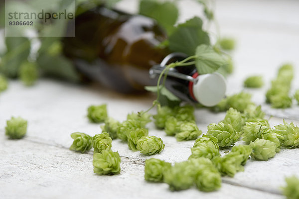 Bierflasche und Hopfen auf einem Holztisch