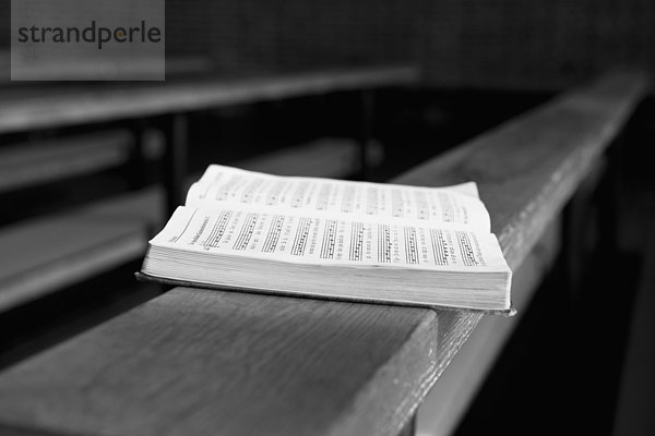 Offenes Gesangbuch auf der Kirchenbank