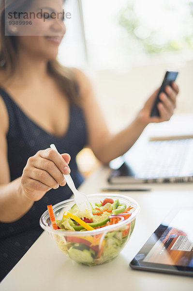 Handy benutzen Frau Salat Büro Kurznachricht essen essend isst