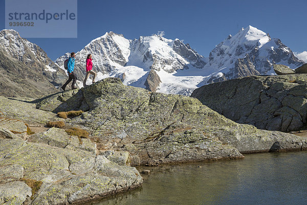 Europa Frau Berg Mann gehen Eis wandern Ansicht Kanton Graubünden Moräne Engadin Schweiz