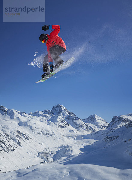 Berg Winter Mann Snowboard Snowboarding springen Ski Außenaufnahme Kanton Graubünden Tiefschnee Wintersport