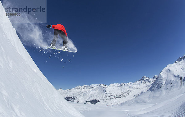Berg Winter Mann Snowboard Snowboarding springen Ski Außenaufnahme Kanton Graubünden Tiefschnee Wintersport