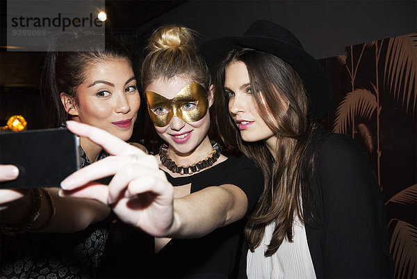 Junge Frauen im Nachtclub nehmen Selfie