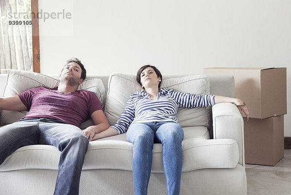 Pärchen beim Umzug auf dem Sofa entspannen