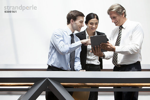 Geschäftskollegen betrachten gemeinsam das digitale Tablett