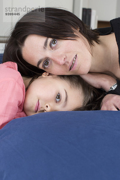 Mutter und Tochter liegen zusammen auf dem Bett  Porträt