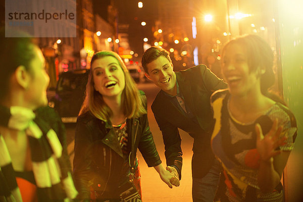 Freunde  die nachts zusammen die Straße entlanggehen.