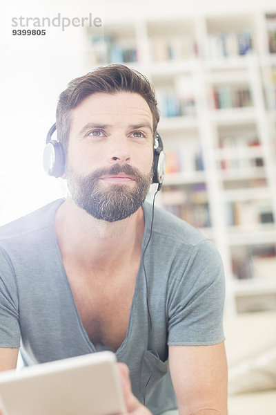 Mann hört Musik im Wohnzimmer