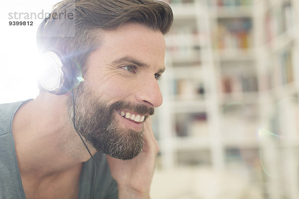 Mann hört Musik im Wohnzimmer