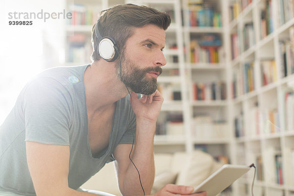 Mann hört Musik im Wohnzimmer