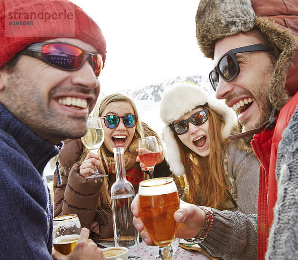 Freunde feiern mit Getränken im Schnee