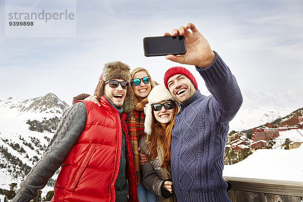 Freunde beim gemeinsamen Fotografieren im Schnee