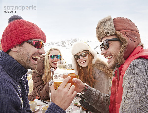 Freunde beim Feiern mit Getränken im Schnee