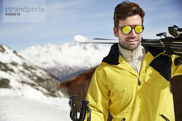 Mann mit Skiern auf dem Berggipfel