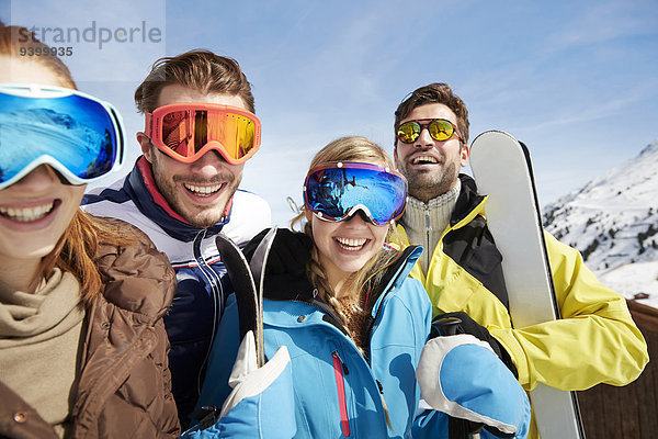 Freunde mit Skiern auf dem Berggipfel