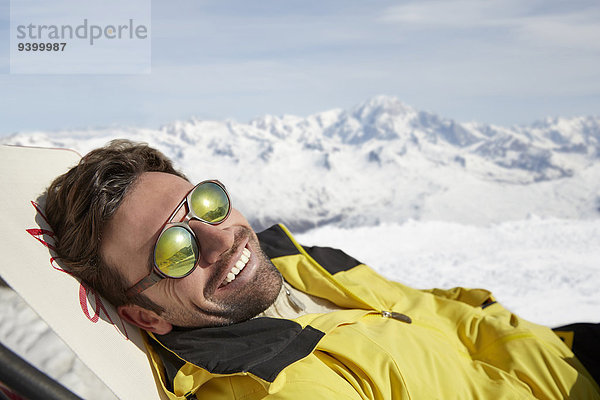 Mann auf einem Stuhl im Schnee liegend