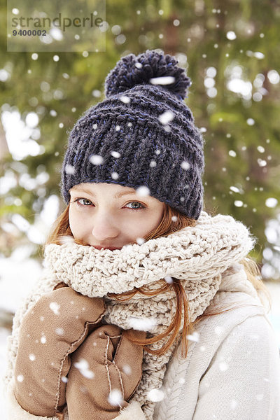 Frau mit Schal und Hut im Schnee