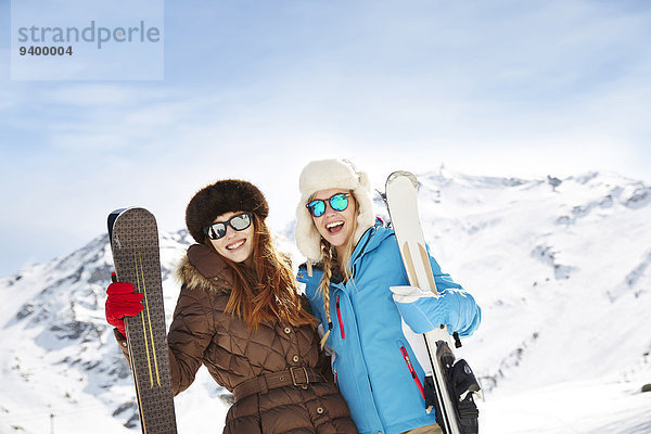 Freunde halten Skier auf Berggipfel zusammen