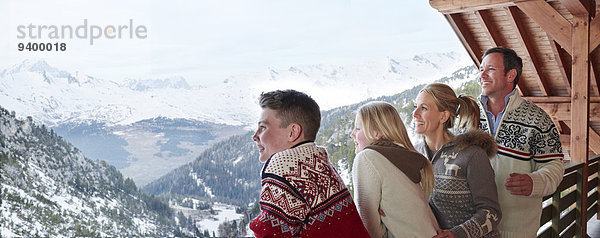 Familie blickt gemeinsam vom Balkon hinaus