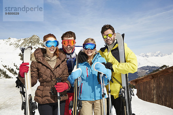 Freunde auf dem Berg halten Skier zusammen.