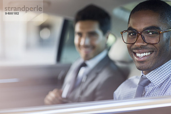 Lächelnde Geschäftsleute im Auto sitzend