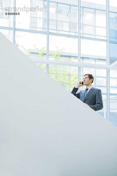 Geschäftsmann beim Telefonieren auf der Bürotreppe