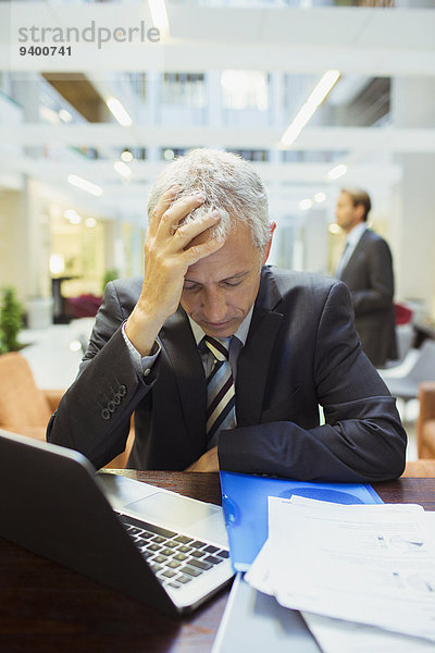 Geschäftsmann ruht sich bei der Arbeit im Bürogebäude aus