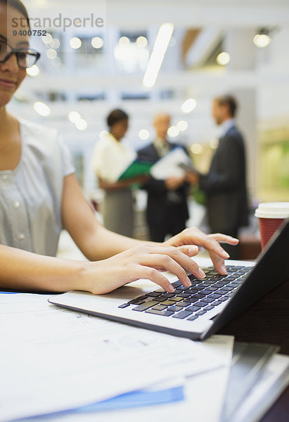 Geschäftsfrau bei der Arbeit am Laptop im Bürogebäude