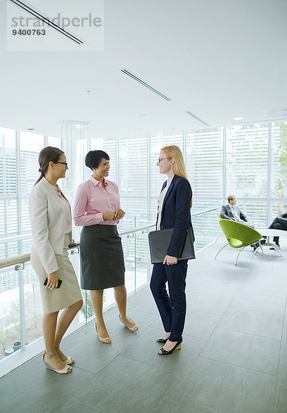 Geschäftsfrauen sprechen im Bürogebäude