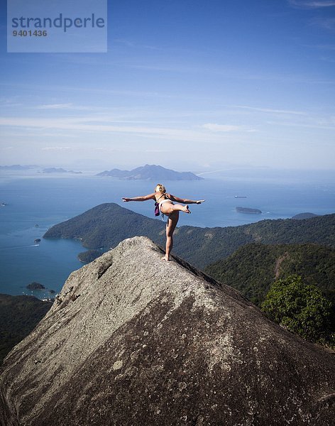 Frau Steilküste üben hoch oben Yoga