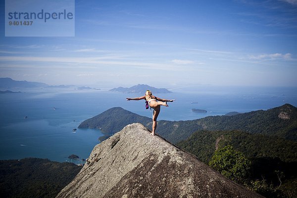 Frau Steilküste üben hoch oben Yoga